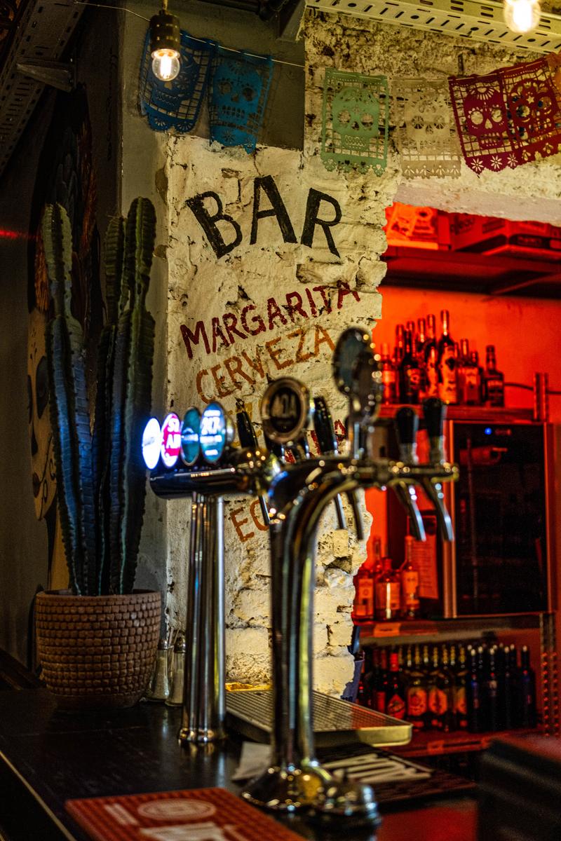 La barra de Agave con la chopera y el cartel pintado Bar, Margarita, Cerveza