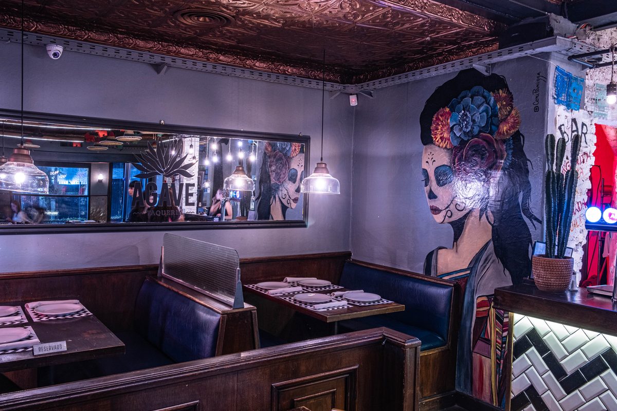 Salón de AGAVE con los murales de calavera y las mesas puestas