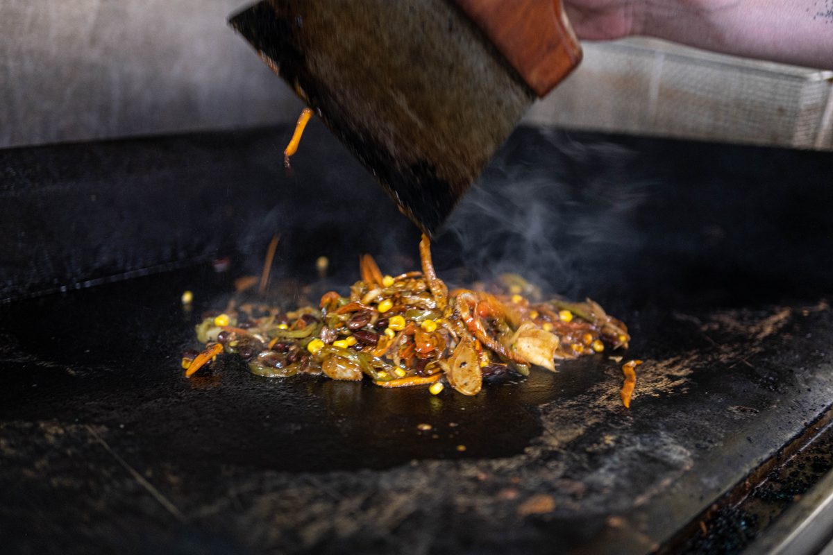 La plancha en llamas mientras se saltea la carne